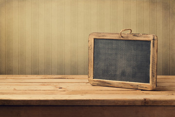 Vintage background with chalkboard on wooden table