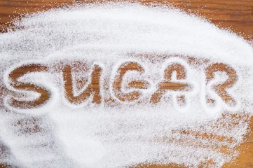 Deurstickers The word sugar written into a pile of white granulated sugar © joanna wnuk
