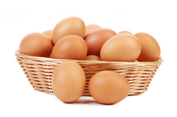 Brown eggs in the basket on white