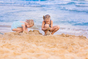 Adorable little girls playing at the seashore