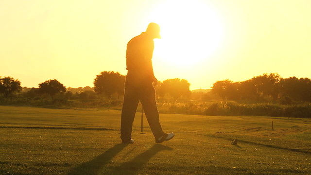 Golfer Following Shot Down Golf Course Fairway Sunset