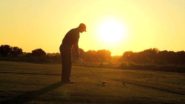 Golfer Driving Off Sunset Golf Resort Fairway 