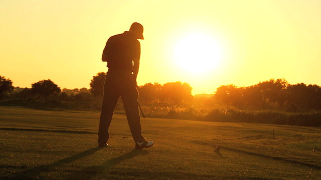 Golfer Following Shot Down Golf Course Fairway Sunset