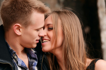 Young enamoured pair a brick wall