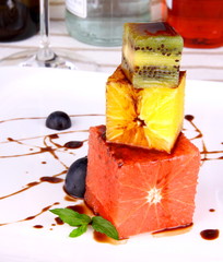 Grapefruit, kiwi and orange dessert with chocolate sauce