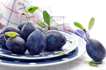 Fresh plums in bright plates