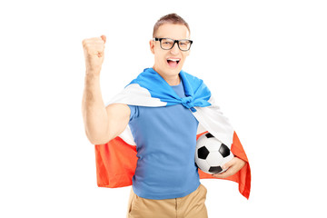Euphoric male fan holding a soccer ball and flag of Holland