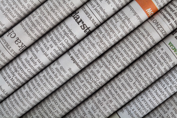 Newspaper headlines shown side on in a stack of daily newspapers