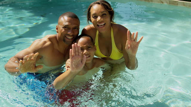 Smiling African American Family Swimming Pool Vacation Promotion