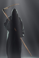 death with scythe standing in the fog at night