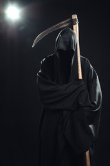 death with scythe standing in the dark