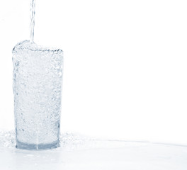 water pouring into glass on white background