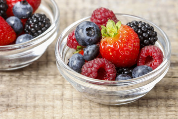Fruit salad in small transparent bowls on wooden table