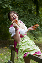 Junge Frau in Dirndl mit Brezeln