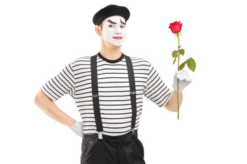 Male mime artist holding a rose flower
