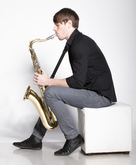 Handsome man playing on saxophone