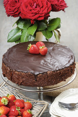 Chocolate cake with strawberries. Birthday party table, wood