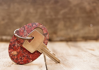 Blank tag and a key on wooden background