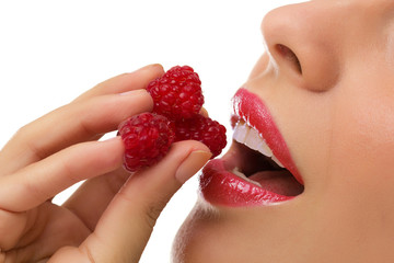 young  beautiful  woman eating raspberries