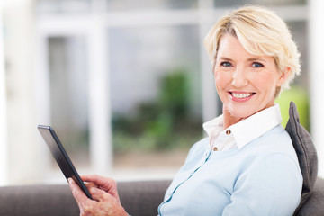 elegant middle aged woman using tablet pc