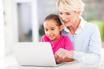modern grandmother teaching grandchild computer
