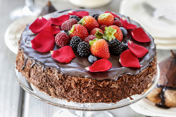 Chocolate cake with strawberries. Birthday party table, wood