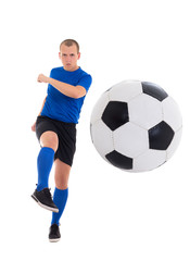 young attractive soccer player in blue uniform kicking ball isol