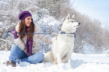 Young woman with her dog in snow