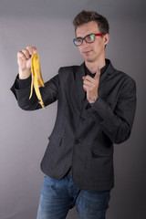 Young businessman holds a banana peel