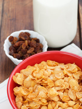 A bowl of cereal with almonds, milk and dried grapes