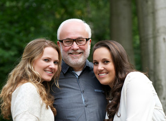 Happy father together with two smiling daughters