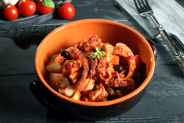 polpo cucinato con patate sfondo grigio