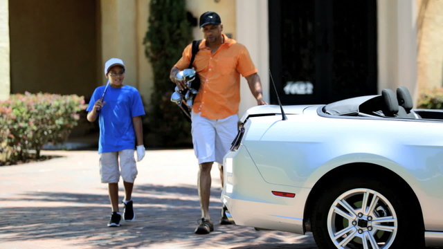 African American Father Son Taking Golf Clubs Car