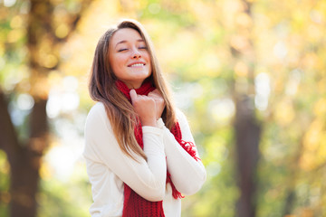 Teen girl in red scarf at autumn outdoor