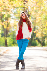 Teen girl in red scarf at autumn outdoor