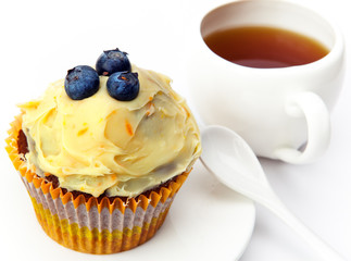 Fruitcake with a berry and a cup of tea