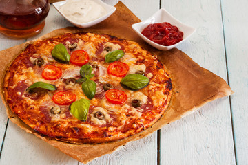 Pizza with salami, tomatoes and olives