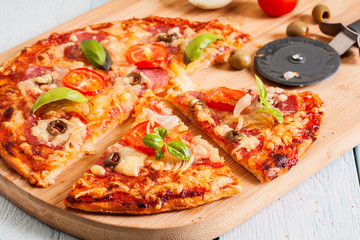 Pizza with salami, tomatoes and olives