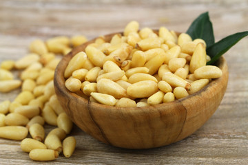 Pine nuts in wooden bowl, close up