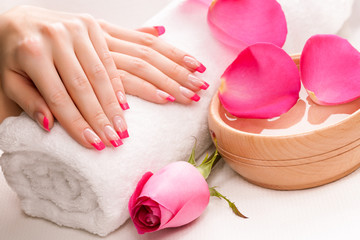 Obraz na płótnie Canvas manicure with fragrant rose petals and towel. Spa