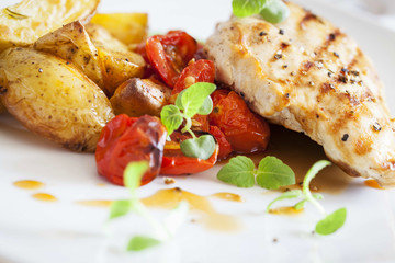 Grilled chicken breast with rosemary potatoes and cherry tomatoe