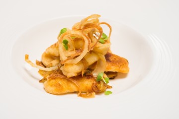 Fried pieces of fish on white plate
