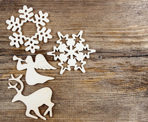 Deer, angel and snowflake shape made of wood on wooden table