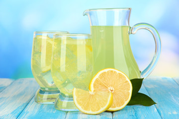 Delicious lemonade on table on blue background