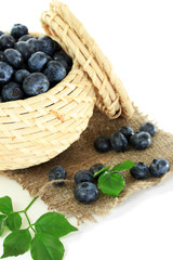 Blueberries in wooden basket on sackcloth isolated on white