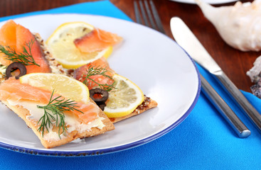 Salmon sandwiches on plate  on wooden table close-up