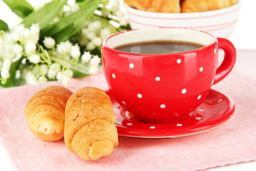 Tasty croissants and cup of coffee close-up
