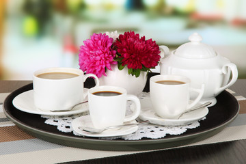 Cups of coffee on tray on table in cafe