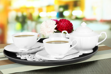 Cups of tea on tray on table in cafe