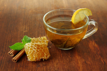 Transparent cup of green tea with honey and cinnamon